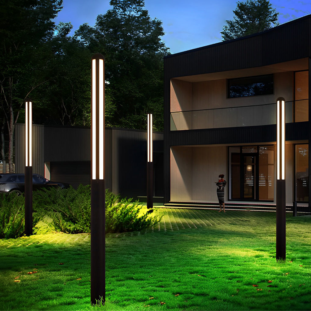 Tall garden bollard light illuminating garden pathway with decorative plants.