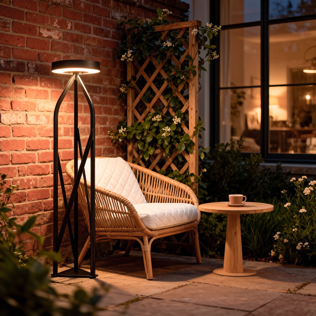 Tall outdoor patio floor lamps creating a warm atmosphere in a cozy outdoor corner with cushioned seating.