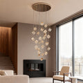 Tall crystal stairs chandelier beside staircase with minimalist interior design.
