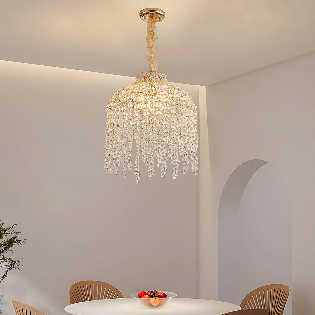 Gold teardrop crystal chandelier illuminating a modern dining room with warm, elegant glow.