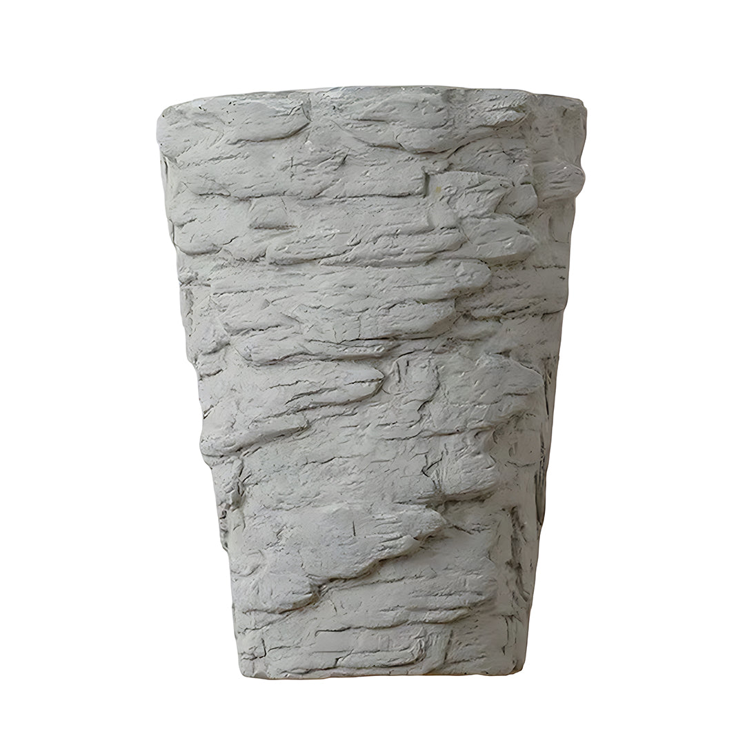 Textured night wall light resembling natural stone creating ambient lighting on white brick wall