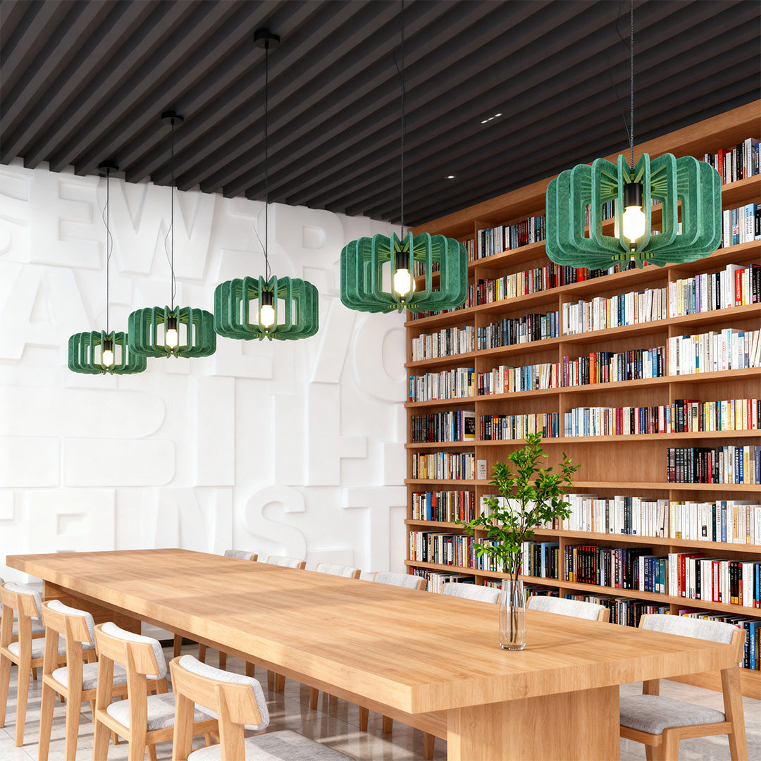 Row of three green felt material Nordic pendant lights illuminating a long library desk.