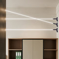Three modern led lights strips for room glowing brightly across a wall above a wooden cabinet.