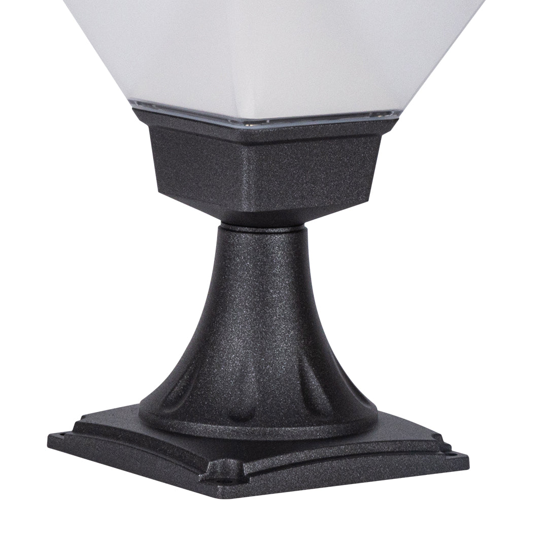 Traditional-style bollard light casting warm glow in naturalistic garden setting