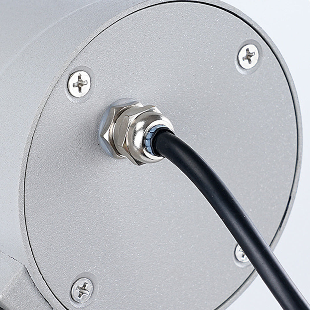 Close-up view of tree spotlight mounting base showing cable connection and ground anchor system