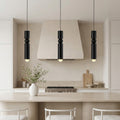 Trio of black cylinder pendant lights featuring a sphere over a luxury marble kitchen island.