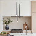 Trio of sleek black multi head pendant lights hanging over a luxury marble kitchen island desk.