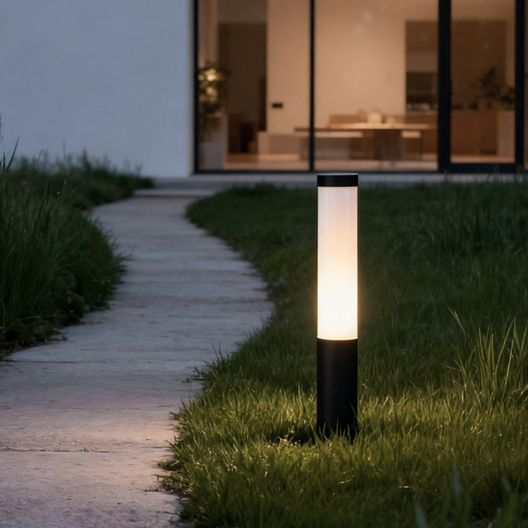 Tube landscape light casting a soft glow on a curved garden path, surrounded by greenery.