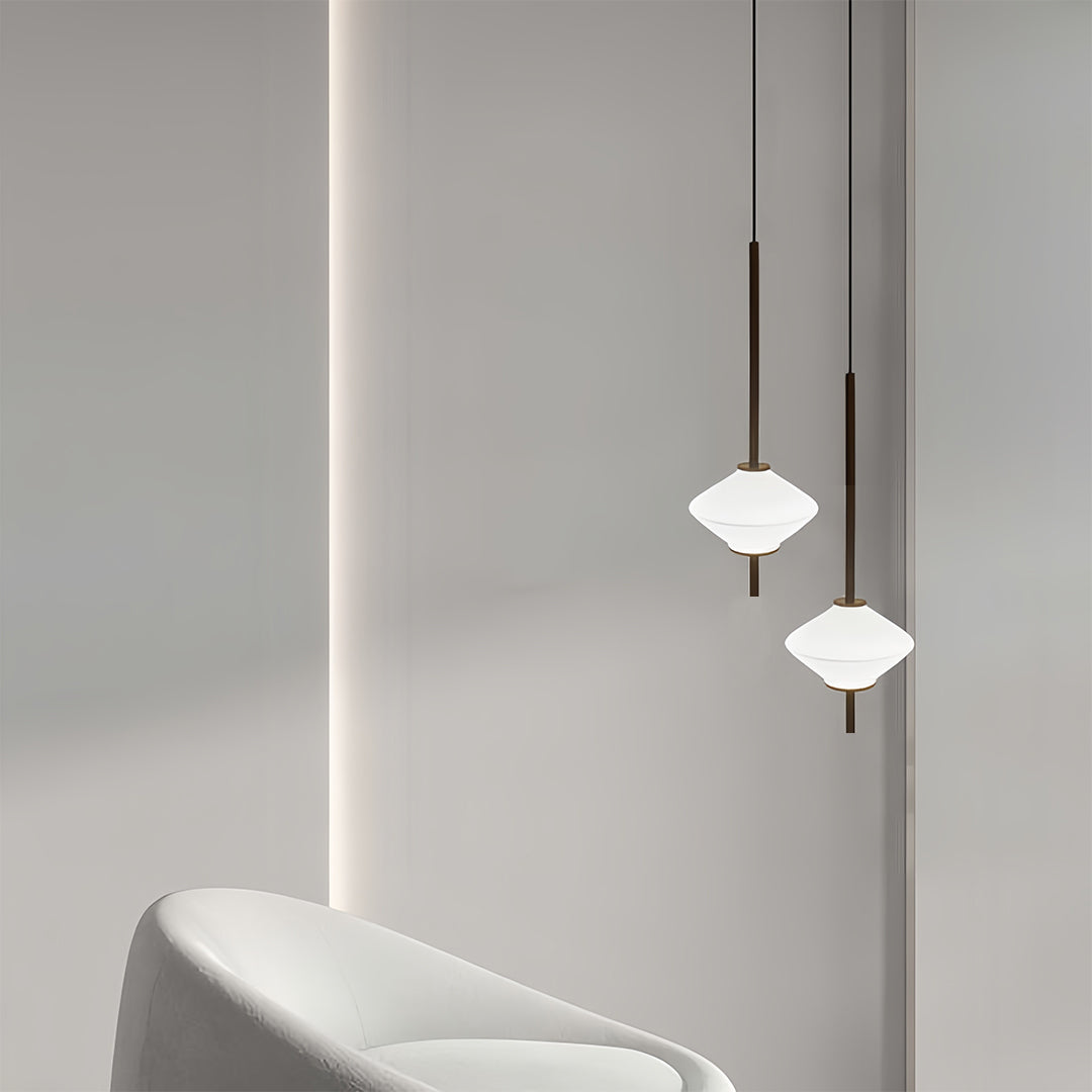 Bedside pendant lights with stacked white disc shades beside modern tub in spa-like bathroom