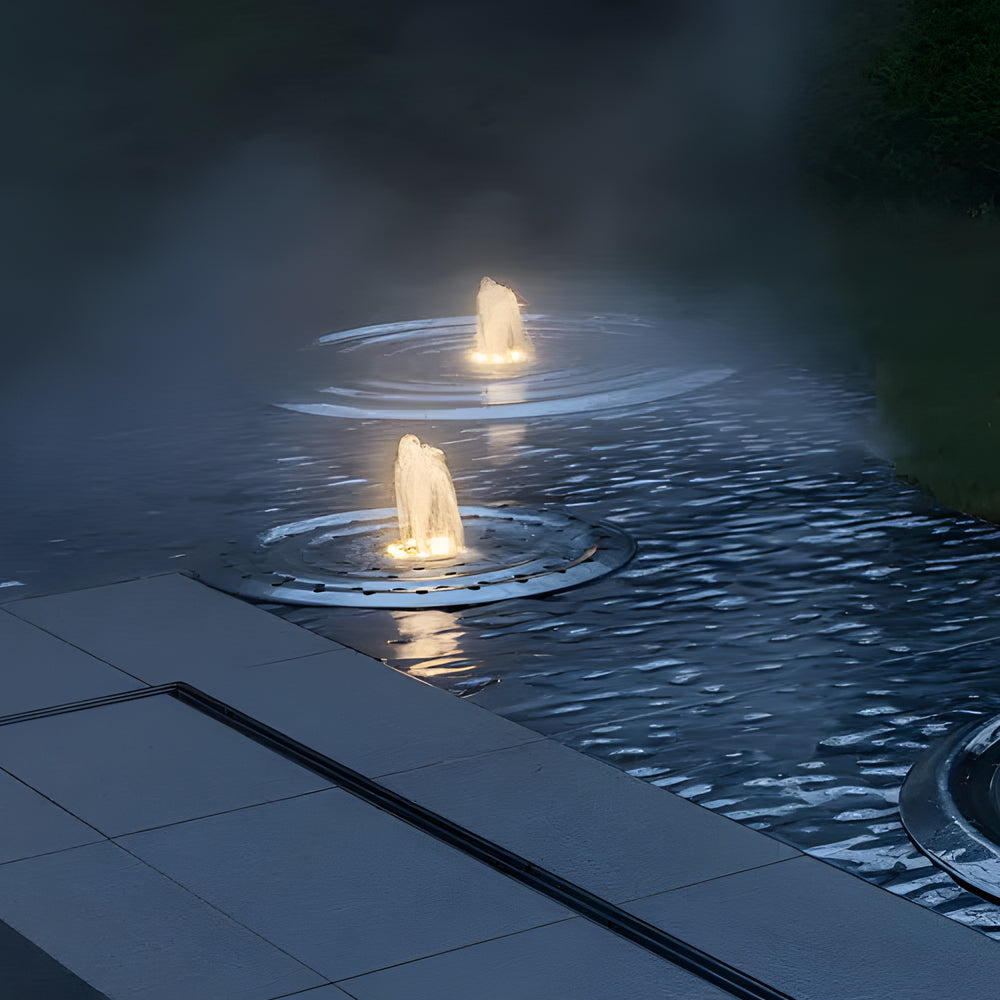 Underwater LED fountain light illuminating water feature with bright white glow at night