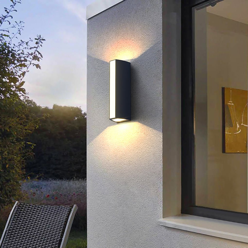 Up down cylinder sconce mounted on a white exterior wall, producing soft ambient lighting for a balcony or patio area.