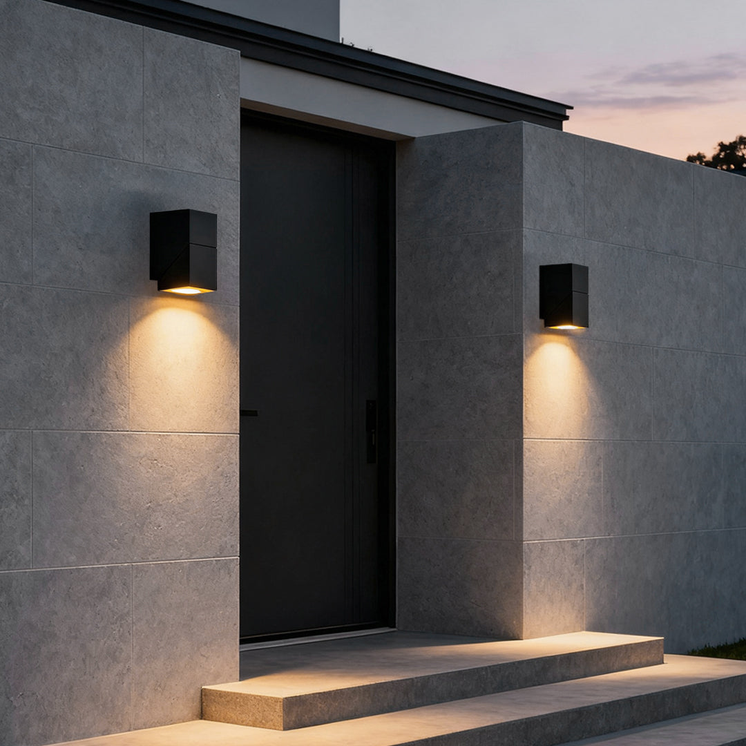 Up down sconce outdoor wall light casting warm glow on steps and door for inviting home entrance ambiance.