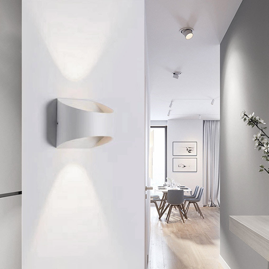 Up and down wall sconce lighting with a black finish, mounted beside a modern bed.