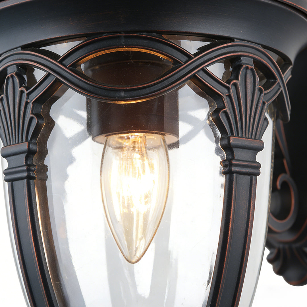 Unique outdoor sconces featuring intricate bronze scrollwork and vintage Edison bulb, perfect for adding classic charm to exterior walls.