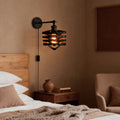 Modern wall mount lights with plug, featuring a vintage industrial design, installed above a cozy bedroom nightstand.