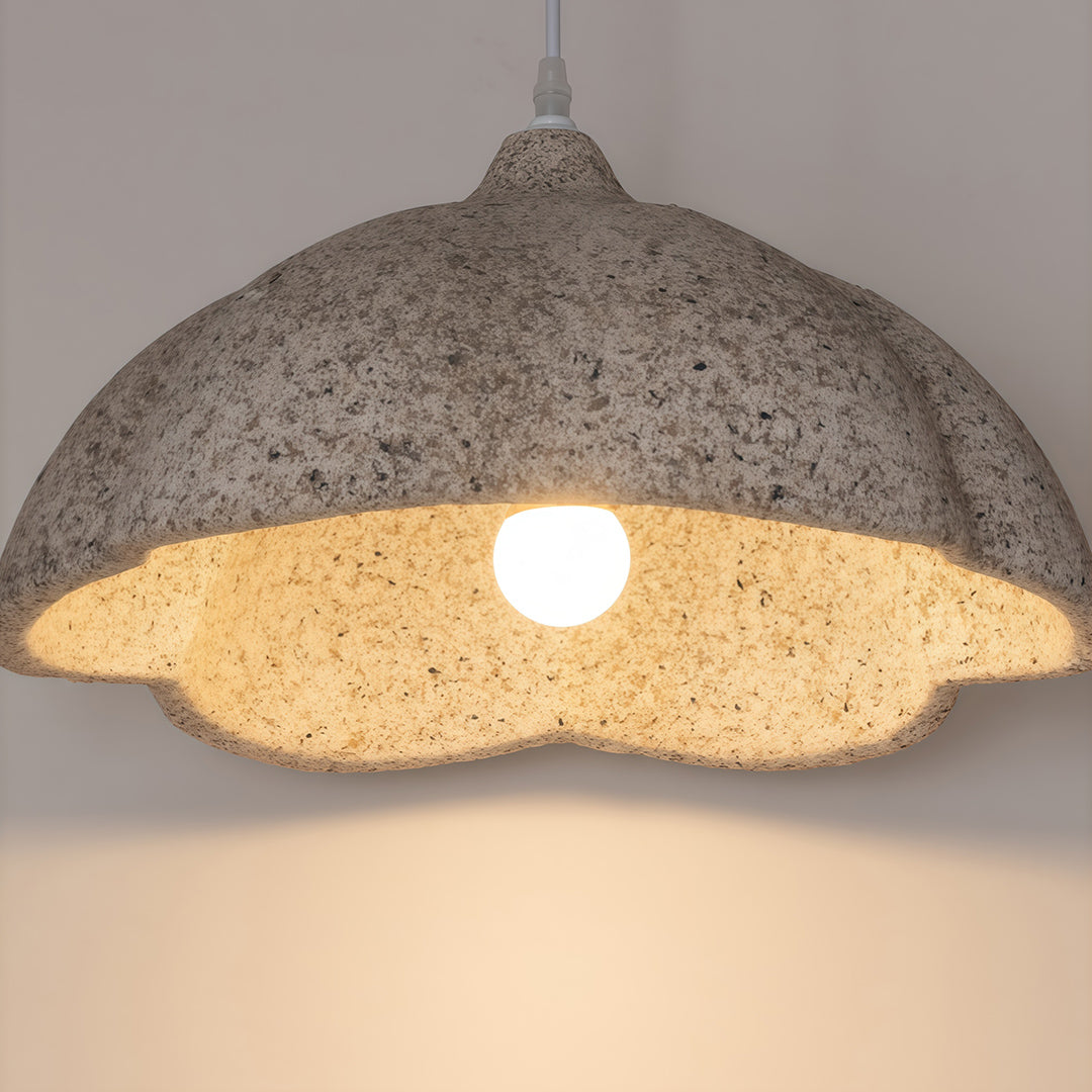 Close-up of vintage metal pendant light showing textured gray finish and warm light bulb inside.
