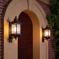 Vintage retro outdoor wall light casting warm light on brick archway entrance at twilight