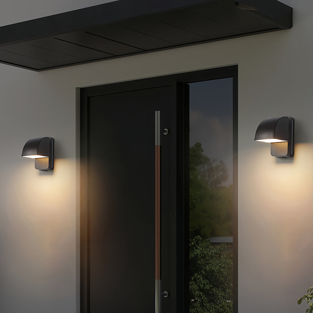 Wall industrial lights mounted on modern gray building with wooden slat accent and house number