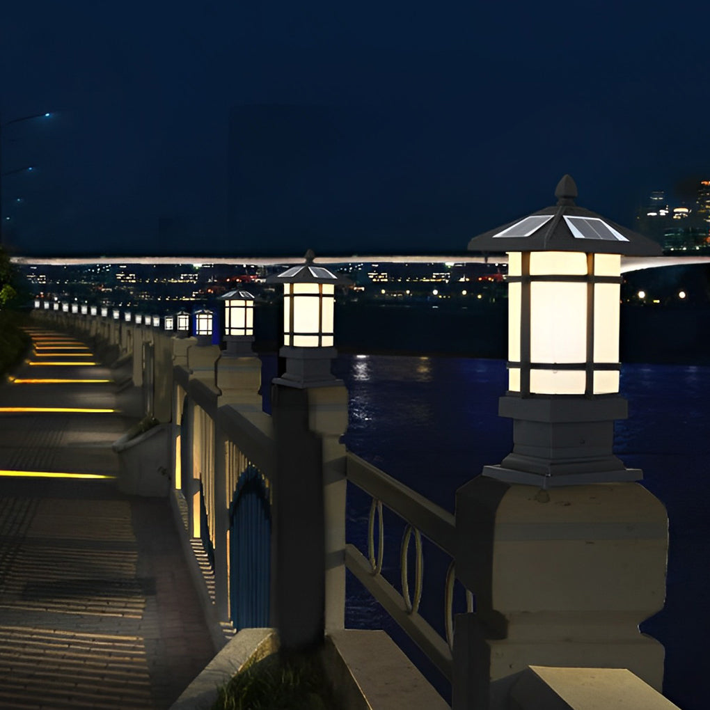 Wall pillar lights outdoor providing warm light beside a decorative fence.