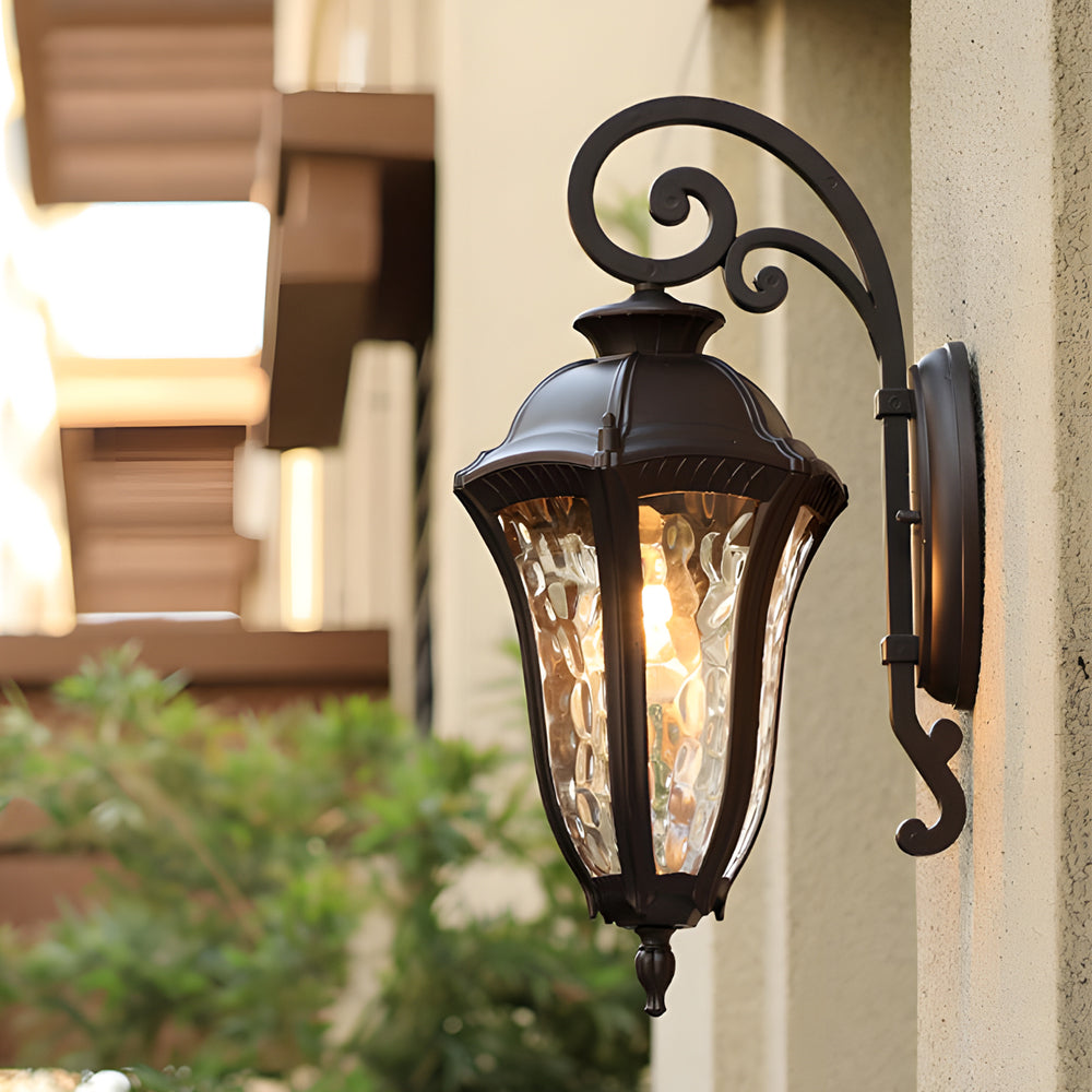 Wall sconce lantern with a decorative design, illuminating an outdoor patio.