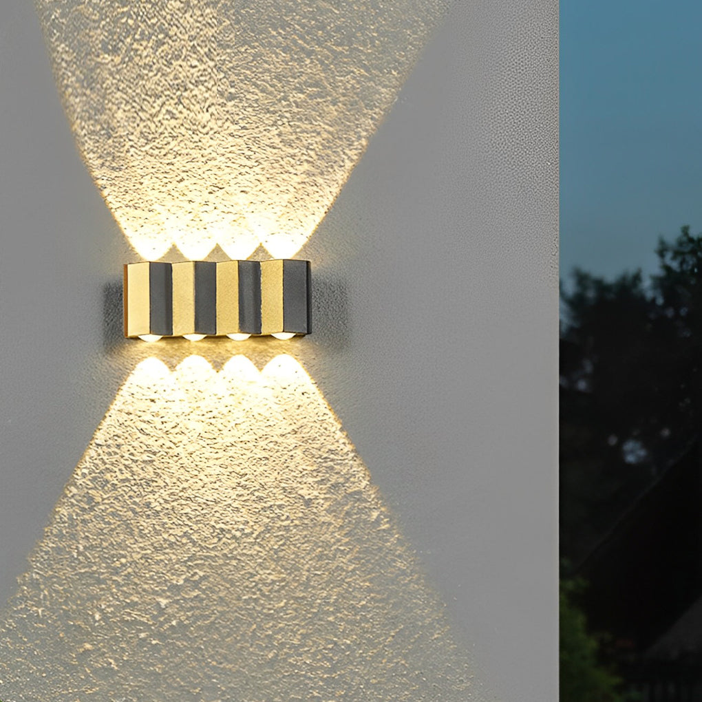 Wall sconce up-down light casting a gentle glow near a textured wall.