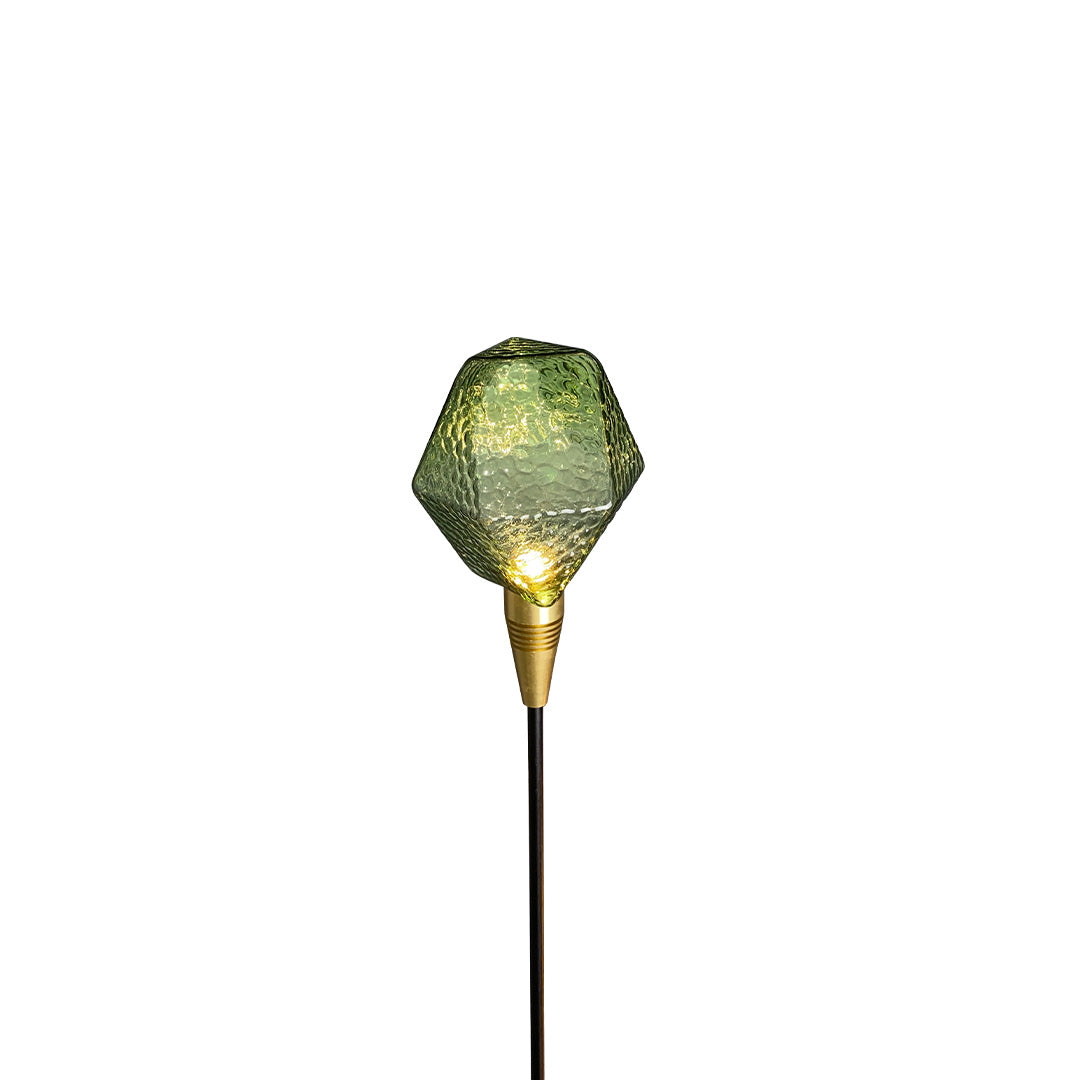 Warm amber globe outdoor stake lamp producing soft illumination for modern landscape lighting pathway setups.