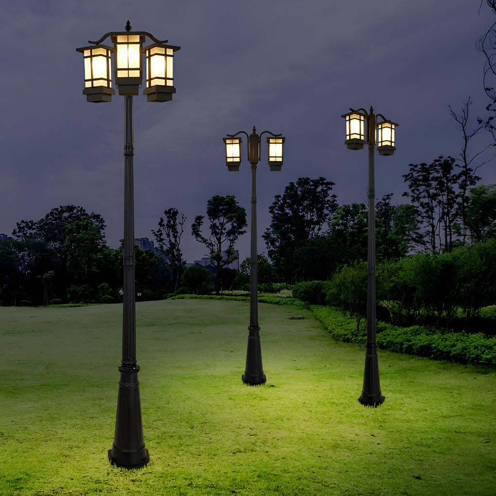 2 head outdoor post light casting warm glow on garden lawn at night.