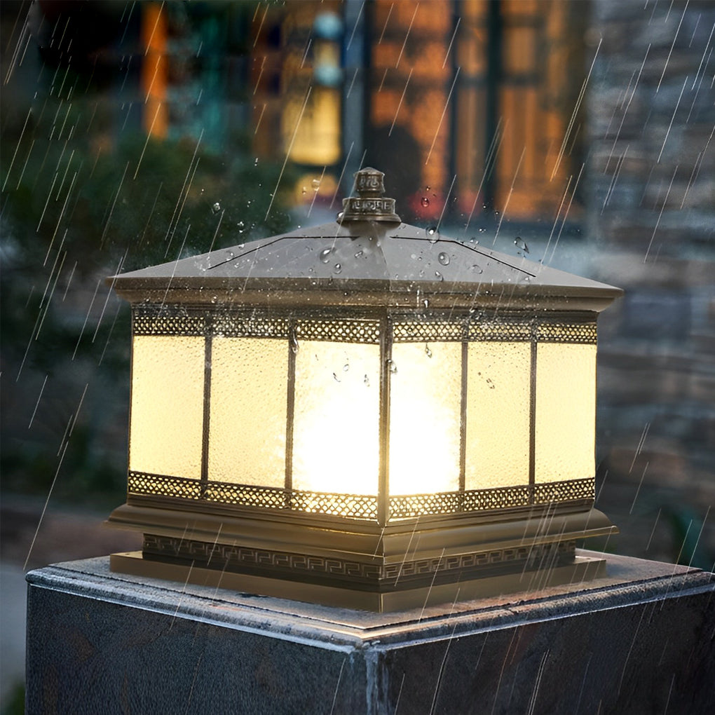 Waterproof outdoor pillar light illuminating stone posts along a garden boundary fence.
