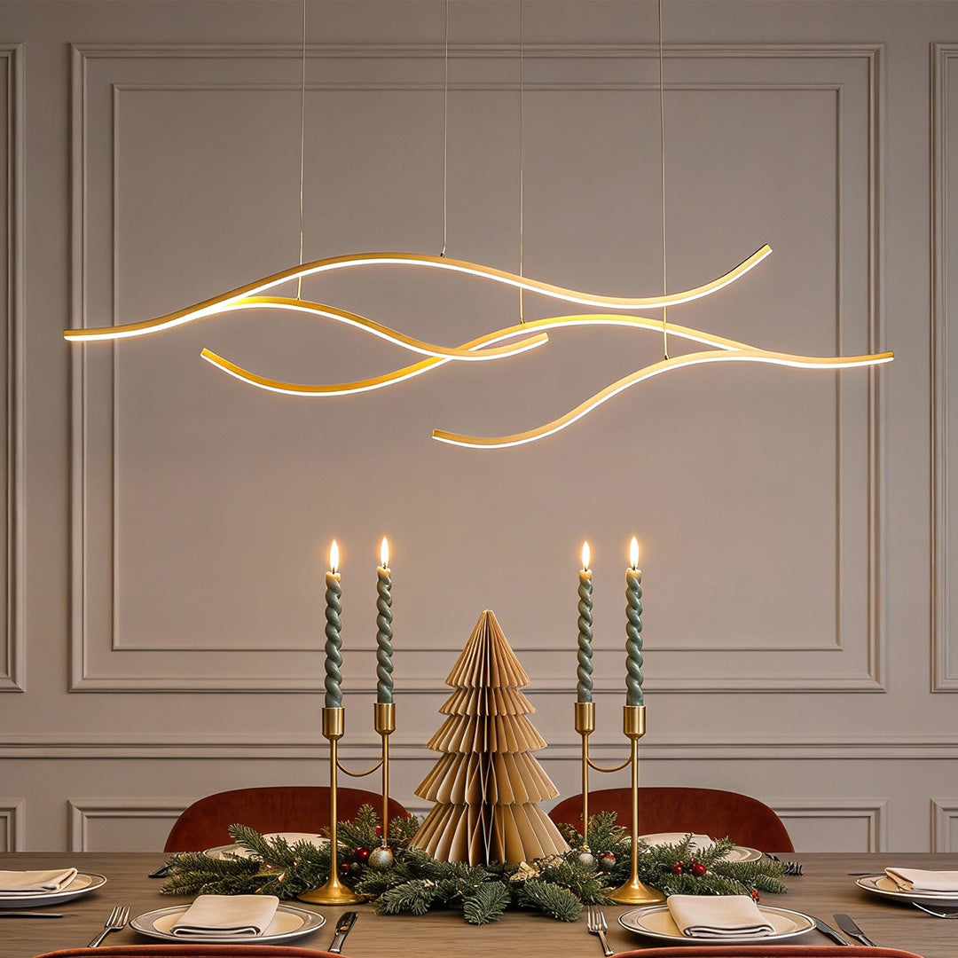 Wave-shaped curved LED pendant light suspended over a formal dining table with decorative candles.