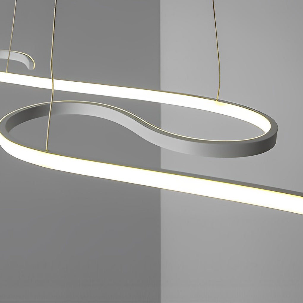 White chandeliers with a minimalist design, hanging from a white ceiling in a modern room.