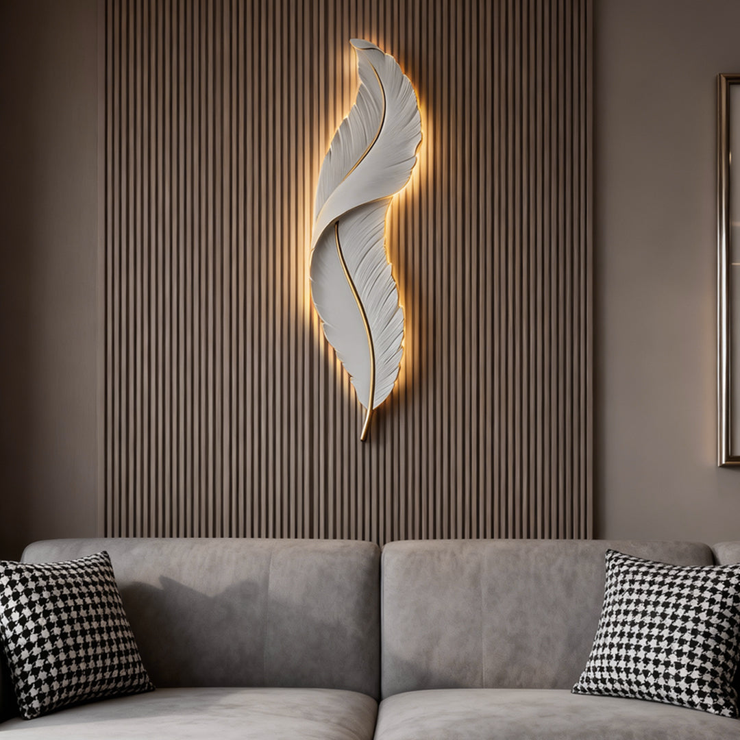 White feather wall light with warm backlight above gray sofa in modern living room.