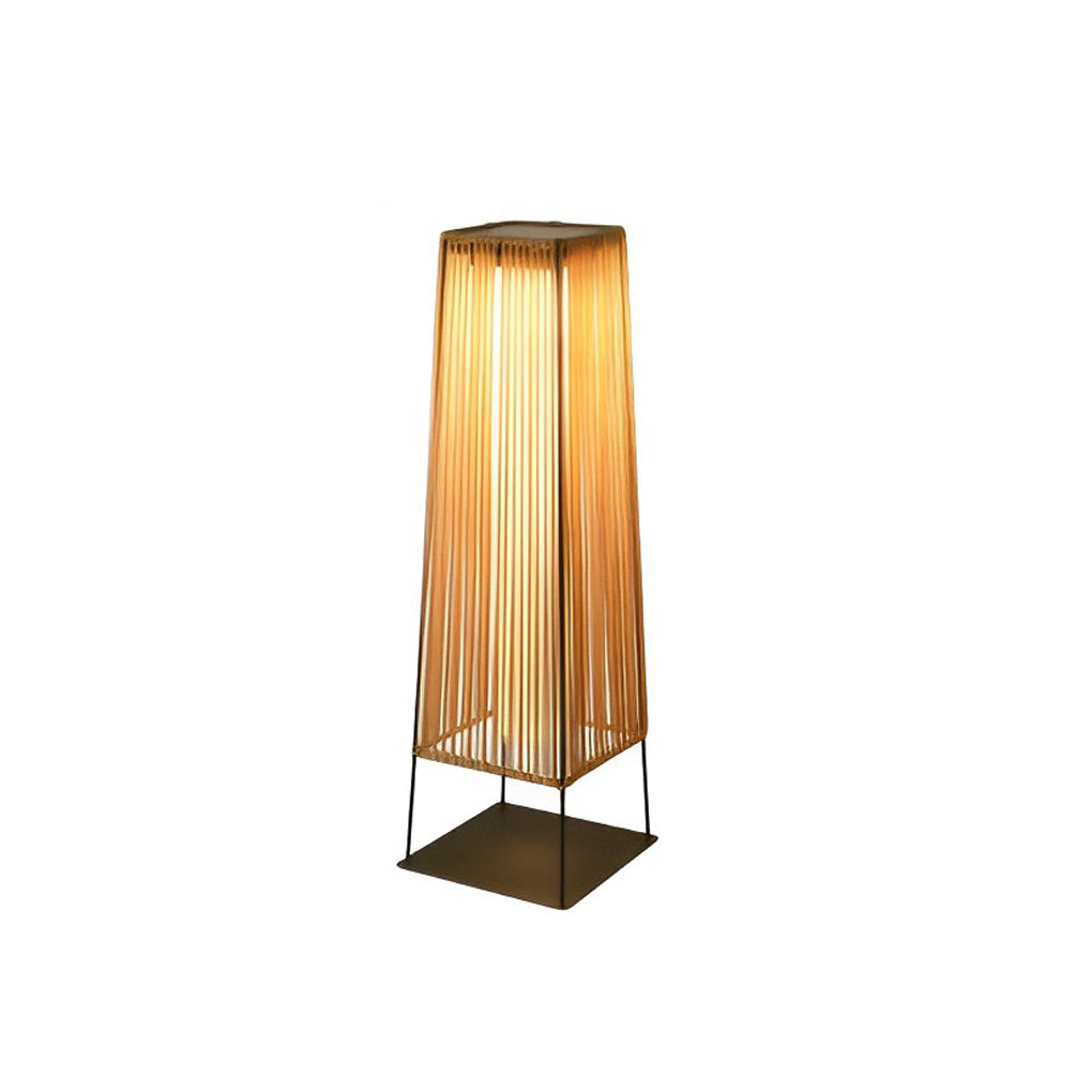 Woven floor lamp with a black base, providing elegant illumination near a sofa.